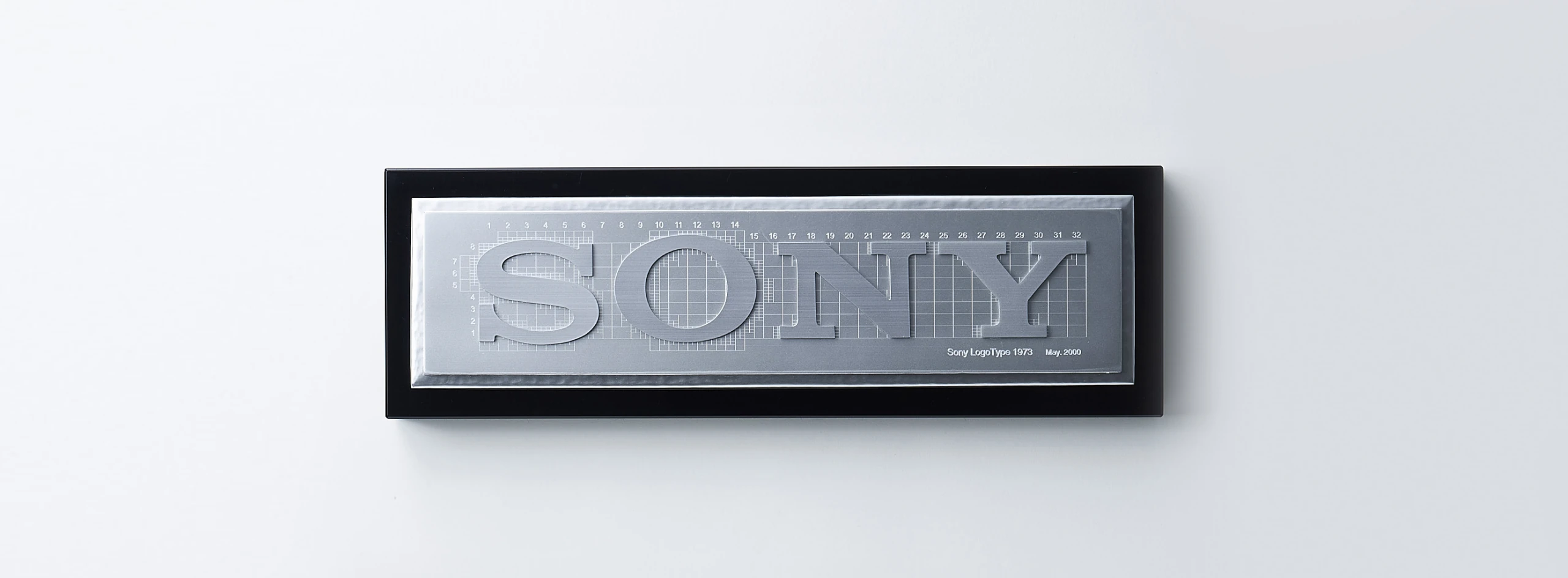Plaque displaying the design grid for the Sony logotype, engraved “Sony LogoType 1973, May. 2000.”