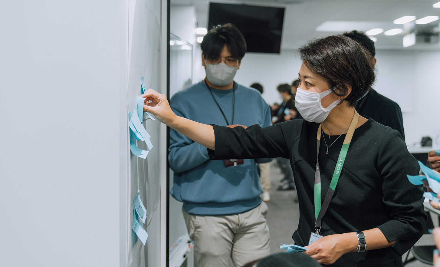 An employee is posting a note on a whiteboard