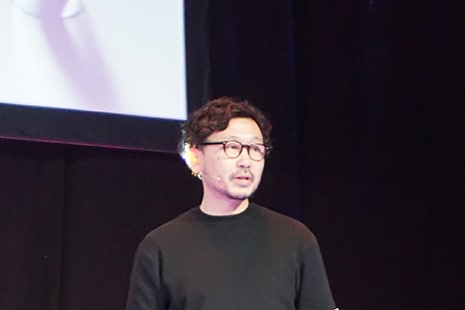 Photo of Hirotaka Tako speaking on stage