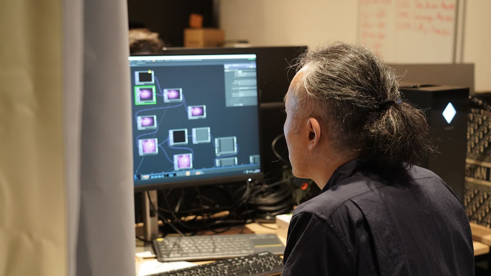 A person backstage looking at a computer screen, testing interactive applications