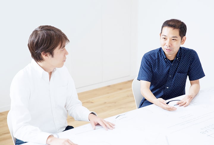 Photo of Okamoto and Ikeda discussing