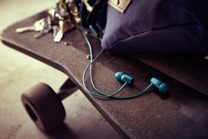 Image of h.ear earbud headphones on a skateboard