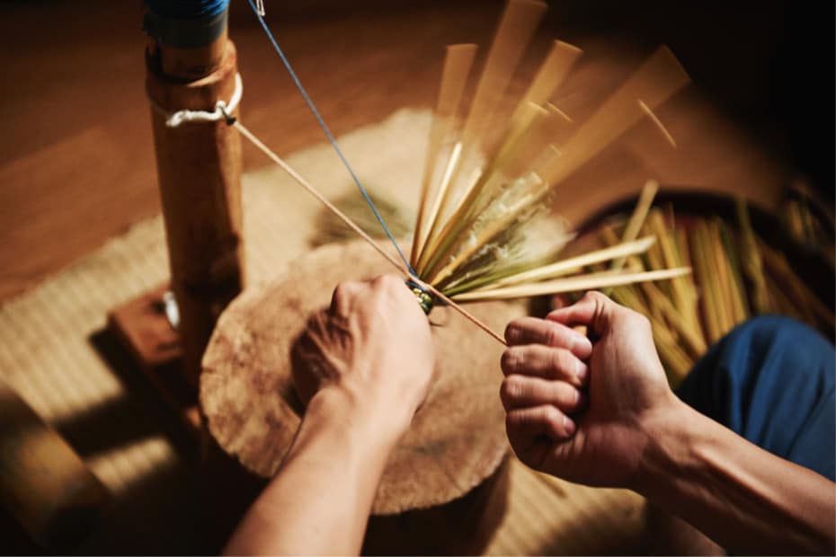 Photo of the stalks being bundled together to create the basic core of the broom