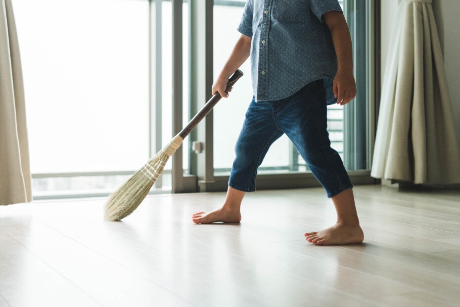 Photo of a child sweeping the floor with a broom for children