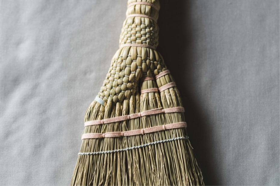 Photo of deep red and pale indigo cotton threads binding the broom corn stalks