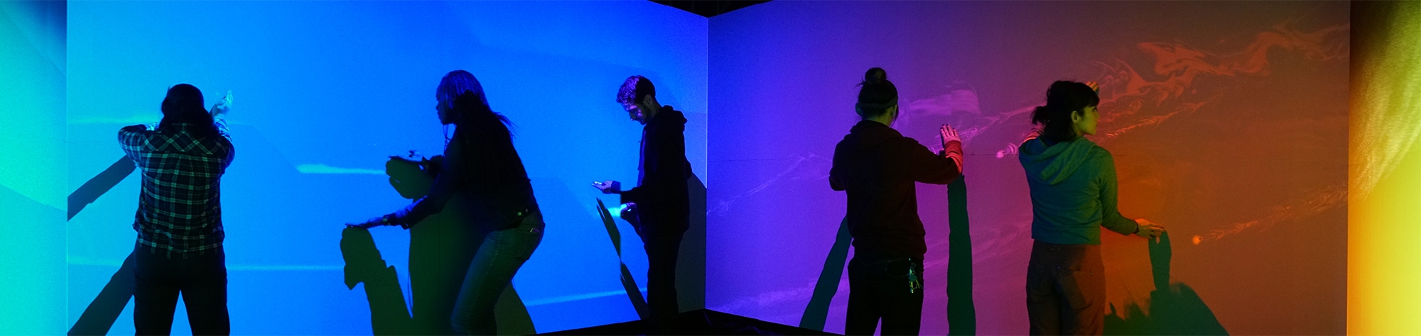 Photo of visitors enjoying the Warp Square where blue graphic is projected