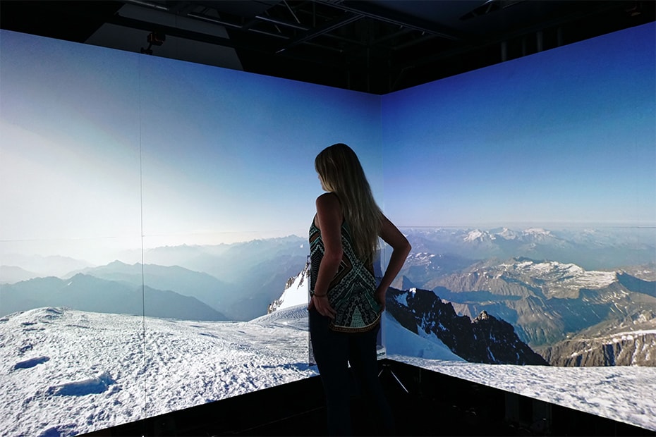 Photo of a visitor enjoying the Warp Square where a view from the top of the mountain is projected