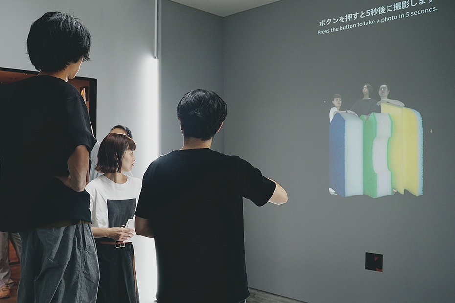 Photo of project members adjusting the size of the photo projected in the experience space