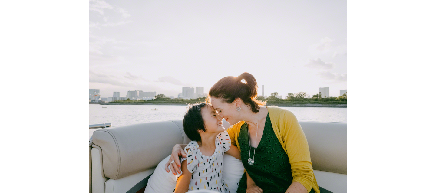 Image of father and daughter hugging by a river