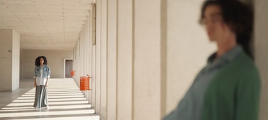 Example image of a woman in the background in focus and a man close to the camera in the foreground out of focus