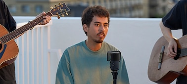 Usage image of a man singing into the microphone on a stand with a guitar player on either side of him