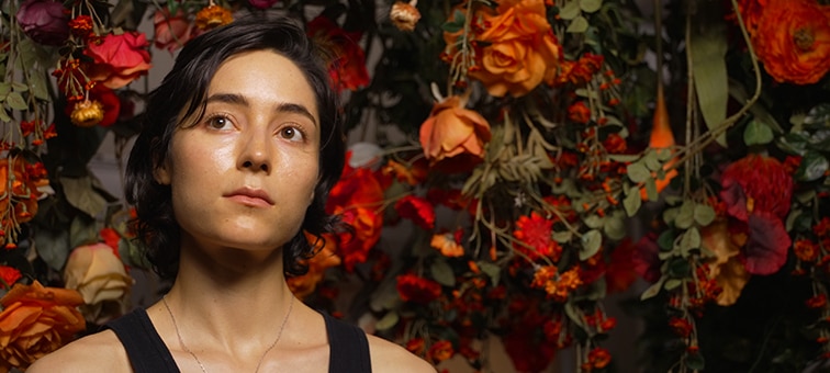 Image of a woman with flowers in the background