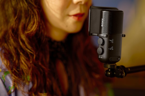 Usage image showing a woman singing with her mouth close to the microphone with pop guard attached