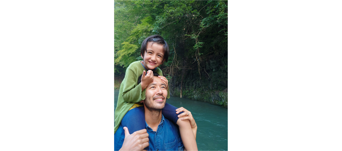 Image of father and daughter hugging by a river