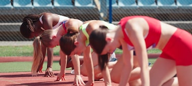 Example image showing four athletes at the start of a women’s hurdle race with focus on the third nearest athlete