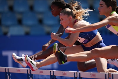 Example image showing three women jumping over the hurdle