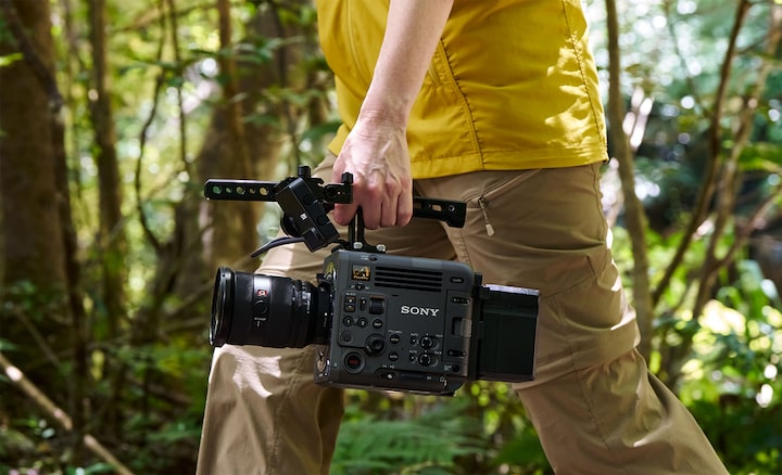 Image of a man holding a camera in one hand