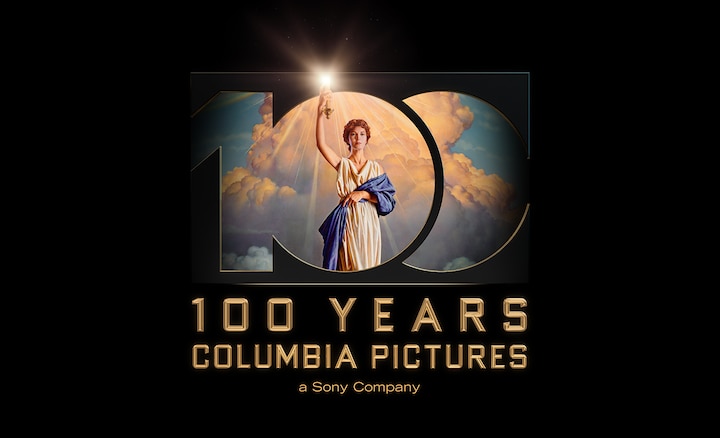 Graphic of the number 100 with a person holding a light against a backdrop of clouds and the caption “100 Years Columbia Pictures” below