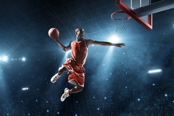 Image of a male basketball player trying to dunk shot.