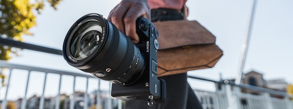 Photo of a woman holding a camera with one hand