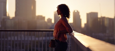 Portrait of a woman silhouetted against a cityscape