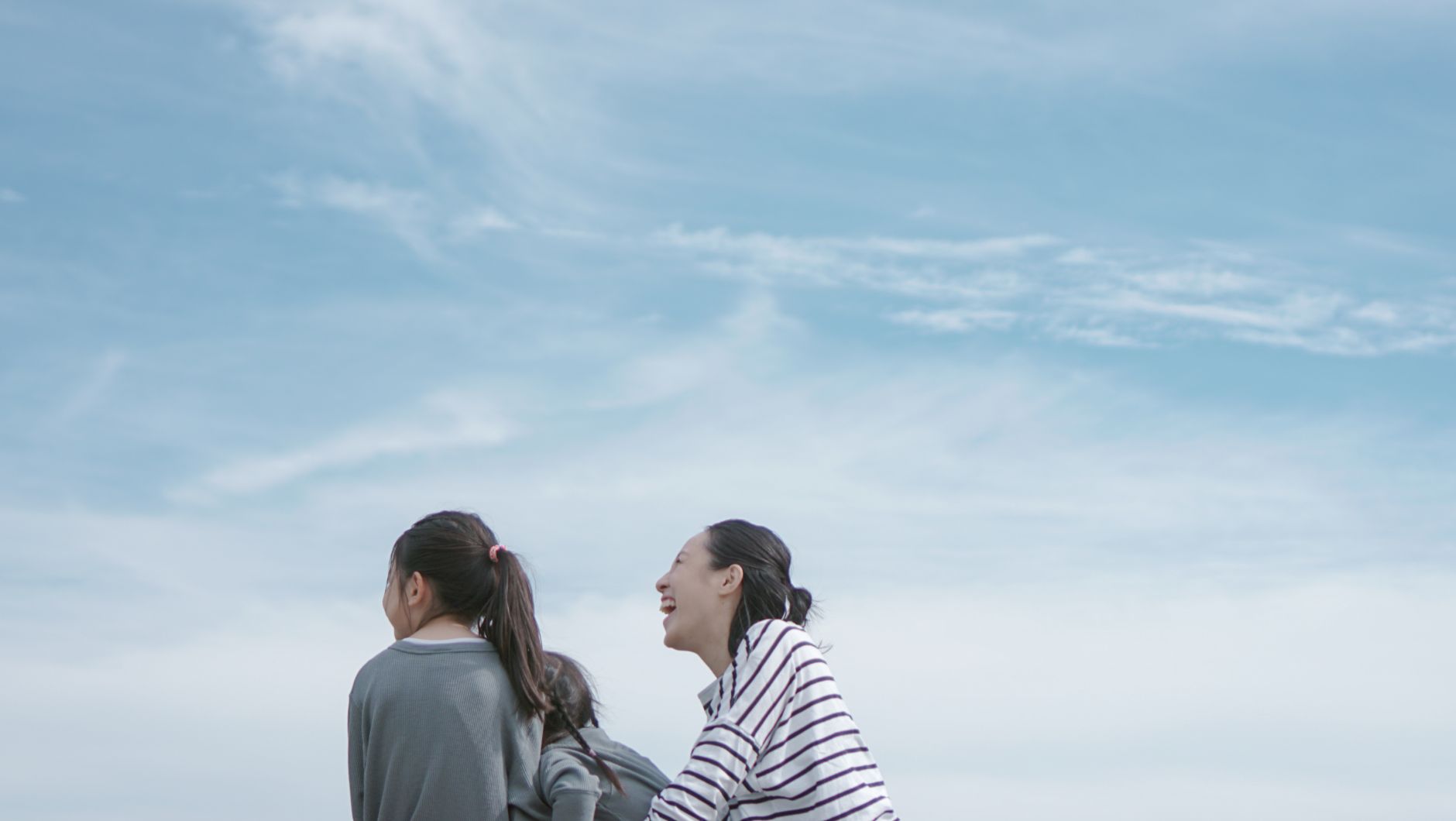 青空の下、自分の子どもと遊んでいる中尾の写真