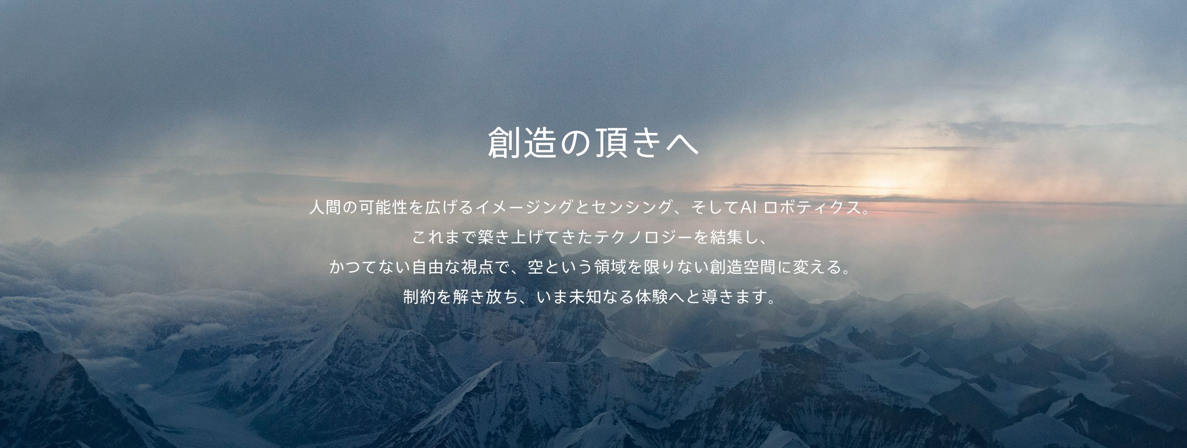 高い山々をさらに上の視点から見た写真を背景にして、Airpeakのステートメント「人間の可能性を広げるイメージングとセンシング、そしてAIロボティクス。これまで築き上げてきたテクノロジーを結集し、かつてない自由な視点で、空という領域を限りない創造空間に変える。制約を解き放ち、いま未知なる体験へと導きます。」を表示しているビジュアル